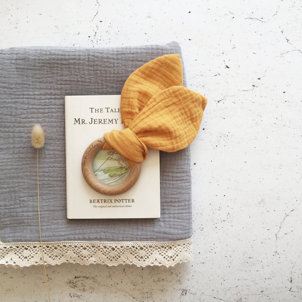 Bunny Ears Baby Teether in Saffron made from organic cotton muslin and natural beechwood. Relieve the pain of your babies teething naturally. 