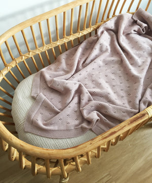 organic cotton knitted baby blanket in dusk in bassinet